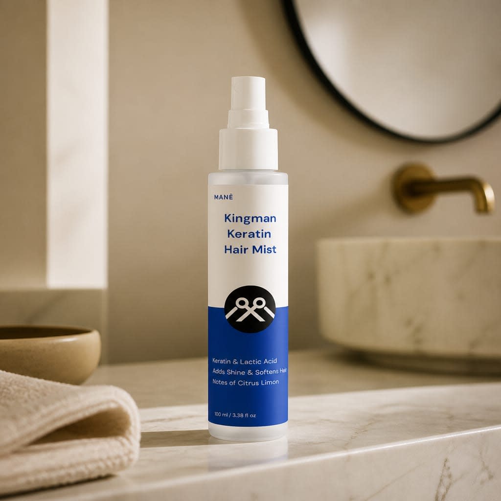 MANË Kingman Keratin Hair Mist white spray bottle with blue label, beside a sink